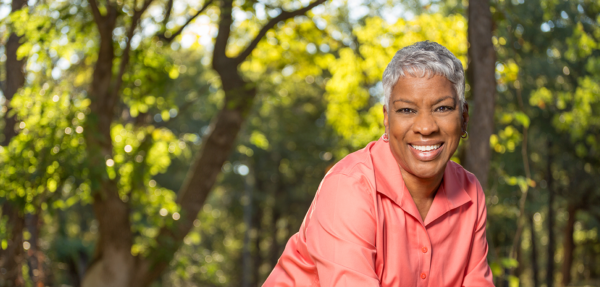 African American female smiling in a nature photo as a cover for the information and assistance page