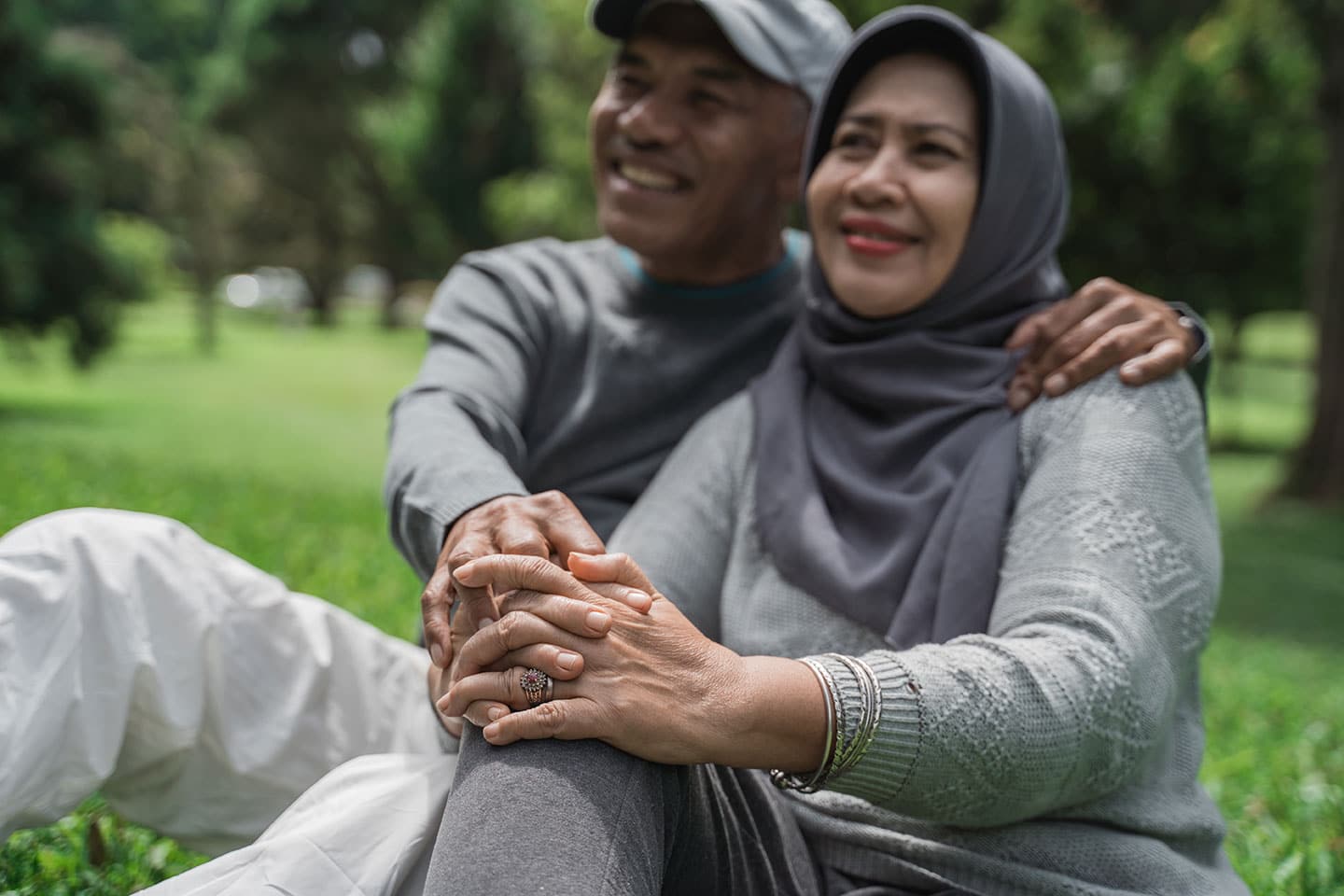 An older Arabic couple sitting in a park spending time together