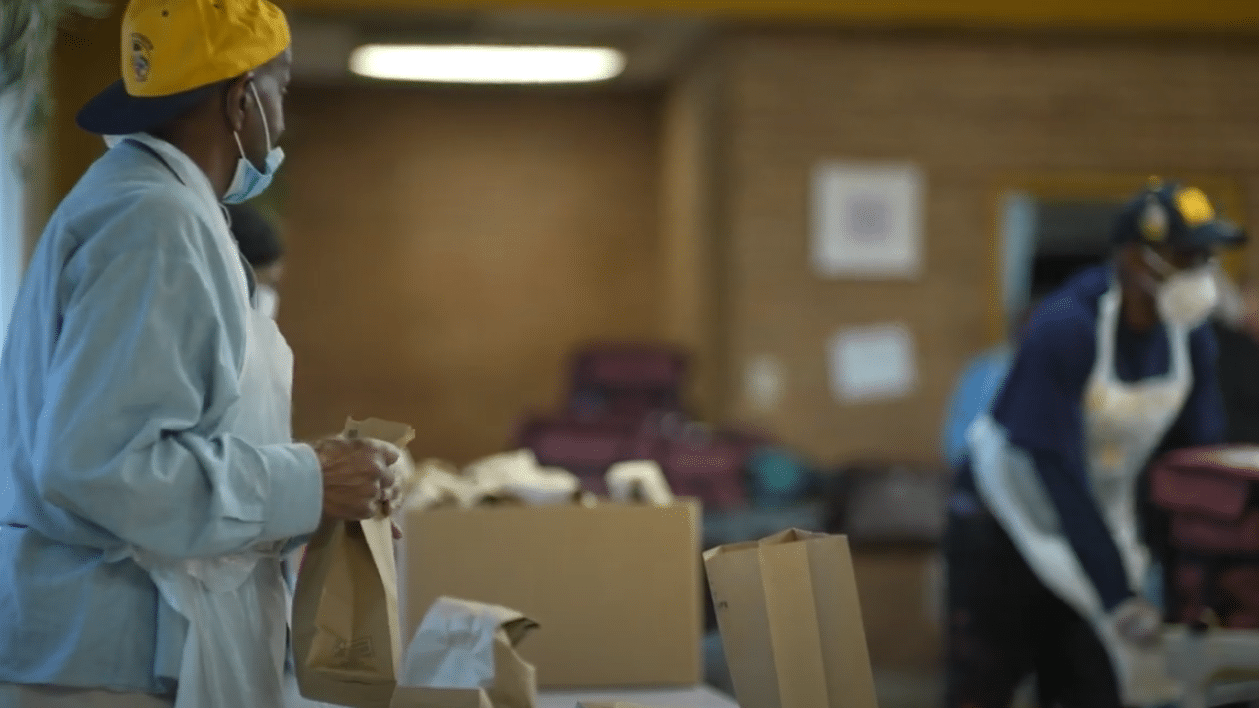 A volunteer finishing the meals on wheels orders by closing the bags
