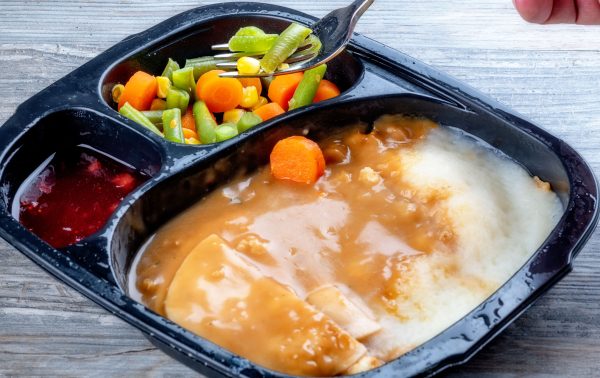 Frozen meal with potatoes, turkey and gravy and mixed vegetables.